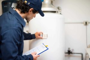 plumber inspecting and fixing leaky water heater
